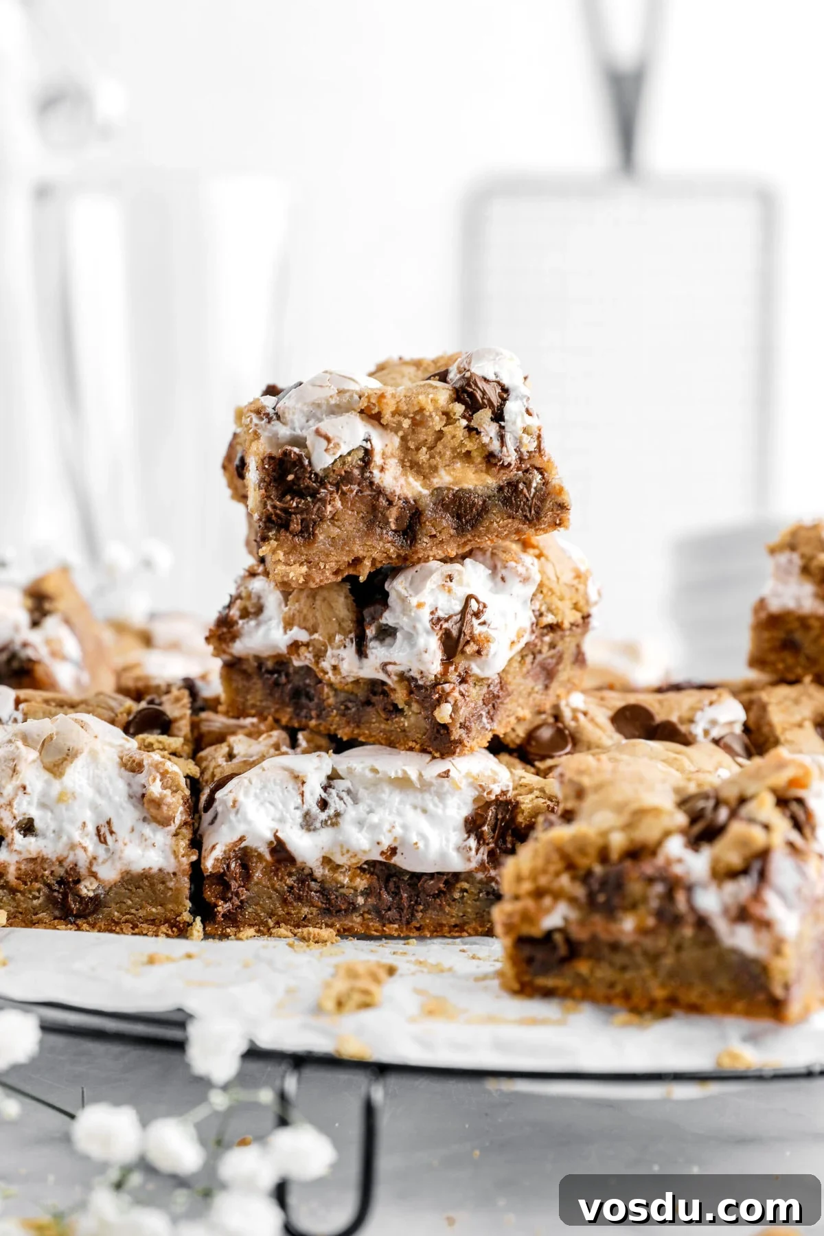 close up of stacked s'mores cookie bars with more bars around.