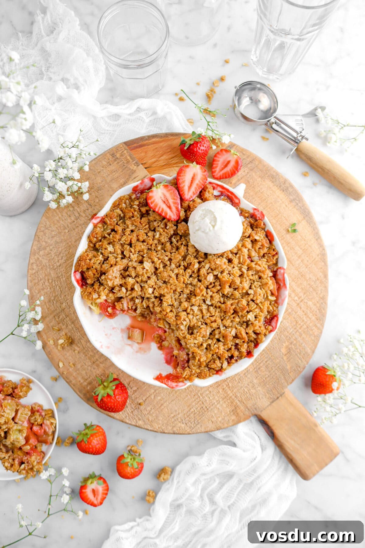 overhead shot of strawberry crisp in pie pan with serving missing