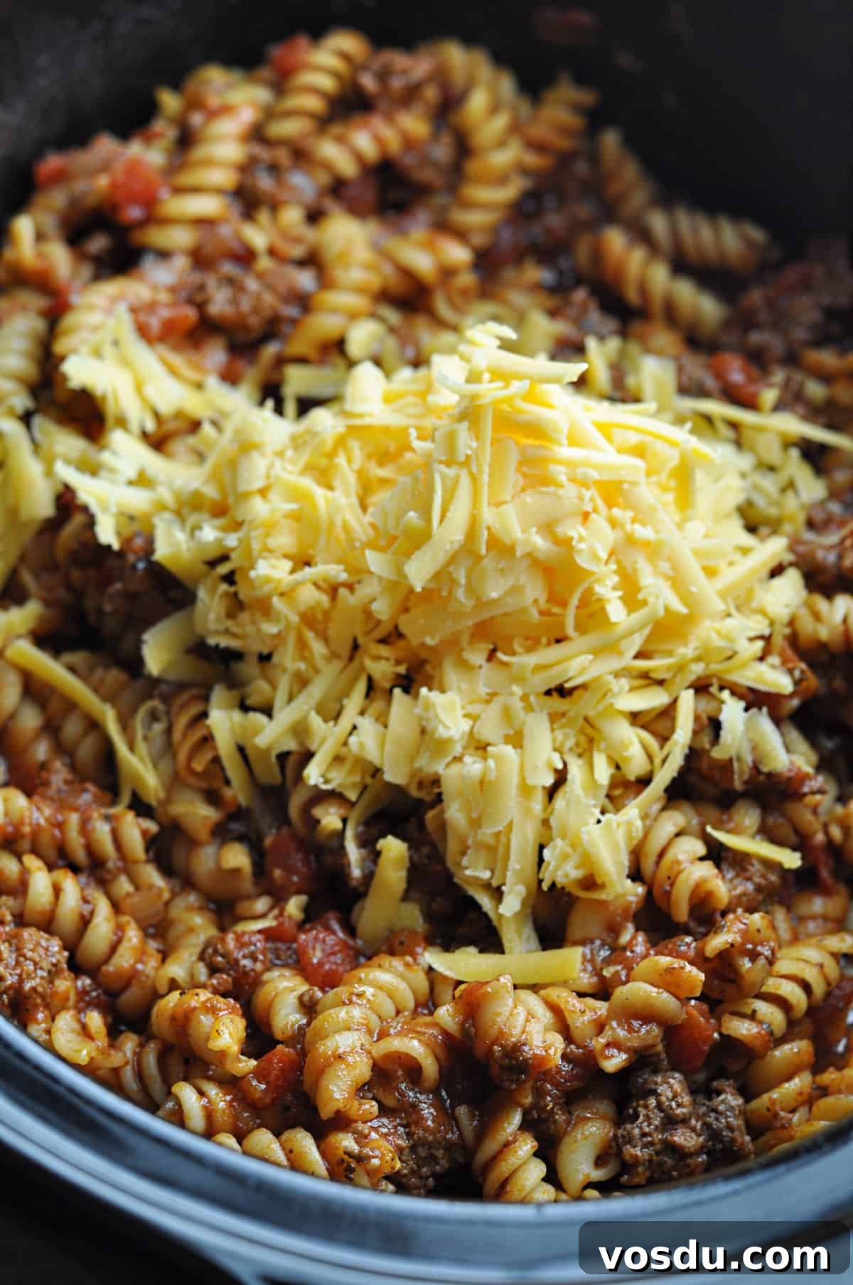 Slow Cooker Hungarian Goulash Recipe for Tender Beef 8 Cooked goulash with ground beef with unmelted cheese on top in slow cooker.