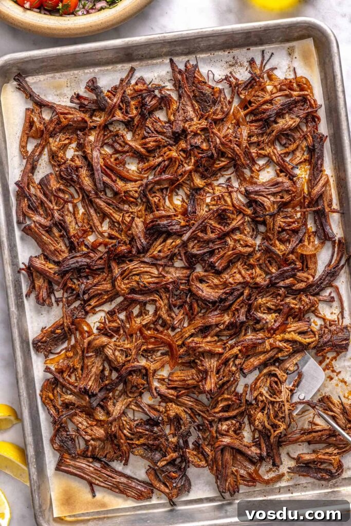 Shredded Greek beef broiled until crispy on a parchment-lined sheet pan