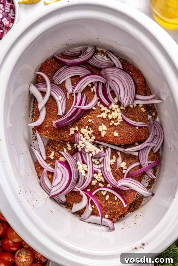 Flank steak with red onion and garlic in a slow cooker for Greek beef bowls