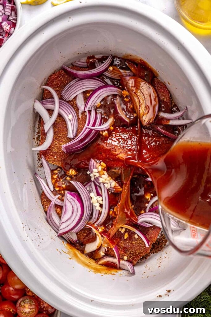Greek braising sauce poured over seasoned flank steak in a crock-pot