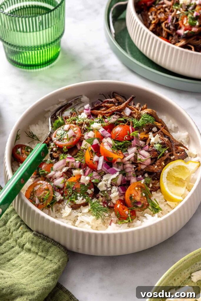 Crispy Greek beef bowls with rice, tomato relish, feta, and lemon wedge