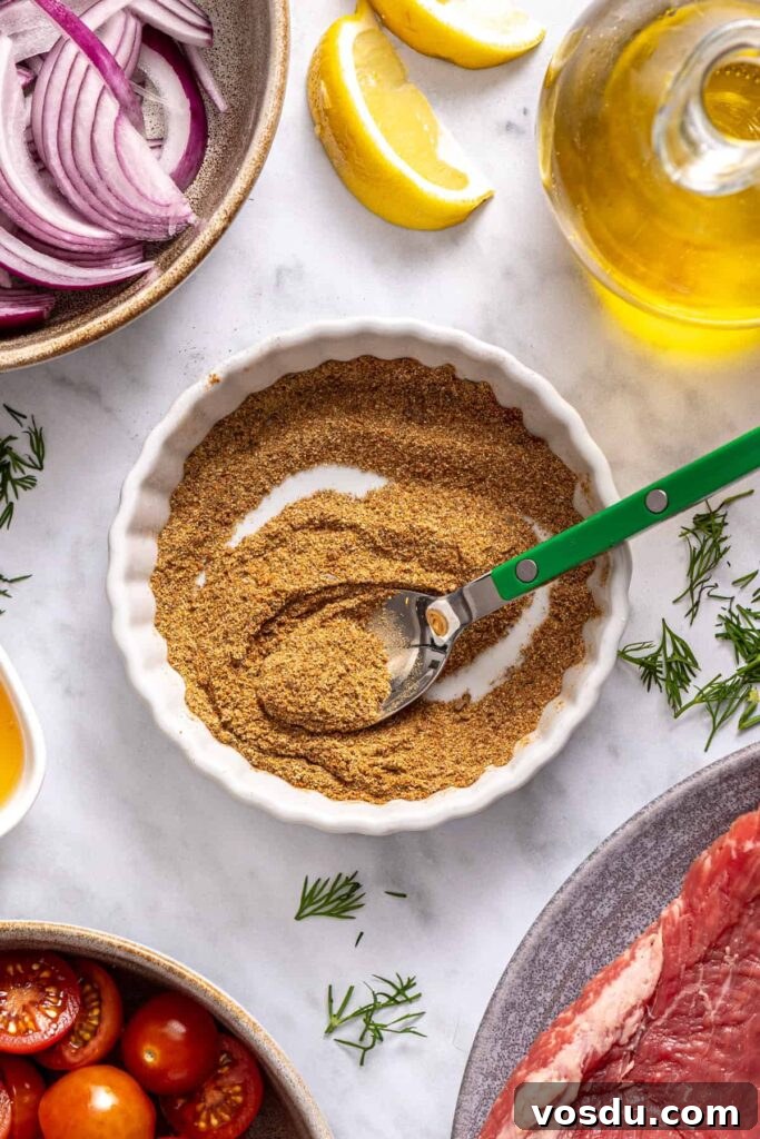 Greek spice blend with cumin, garlic powder, coriander, paprika, and allspice mixed in a small bowl