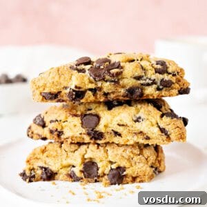 Irresistible Chocolate Chip Scones Recipe for Perfect Breakfast 13 Three chocolate chip scones stacked on a white plate. Pink white background.