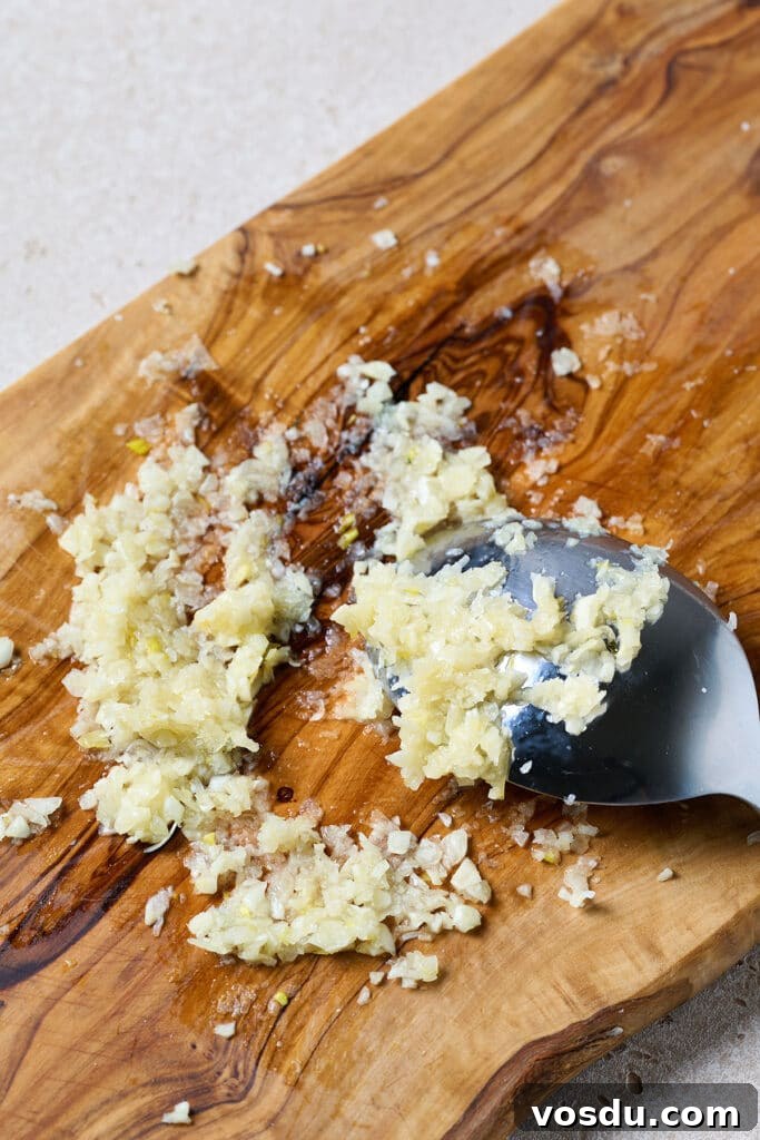 Authentic Cuban Mojo Sauce Recipe for Marinades & Dips 5 Garlic and salt paste made on a cutting board