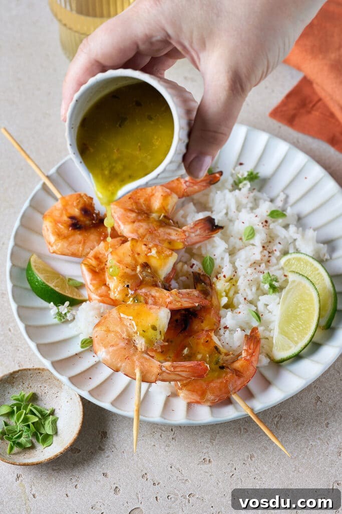 Authentic Cuban Mojo Sauce Recipe for Marinades & Dips 8 Mojo sauce getting poured over shrimp skewers and rice