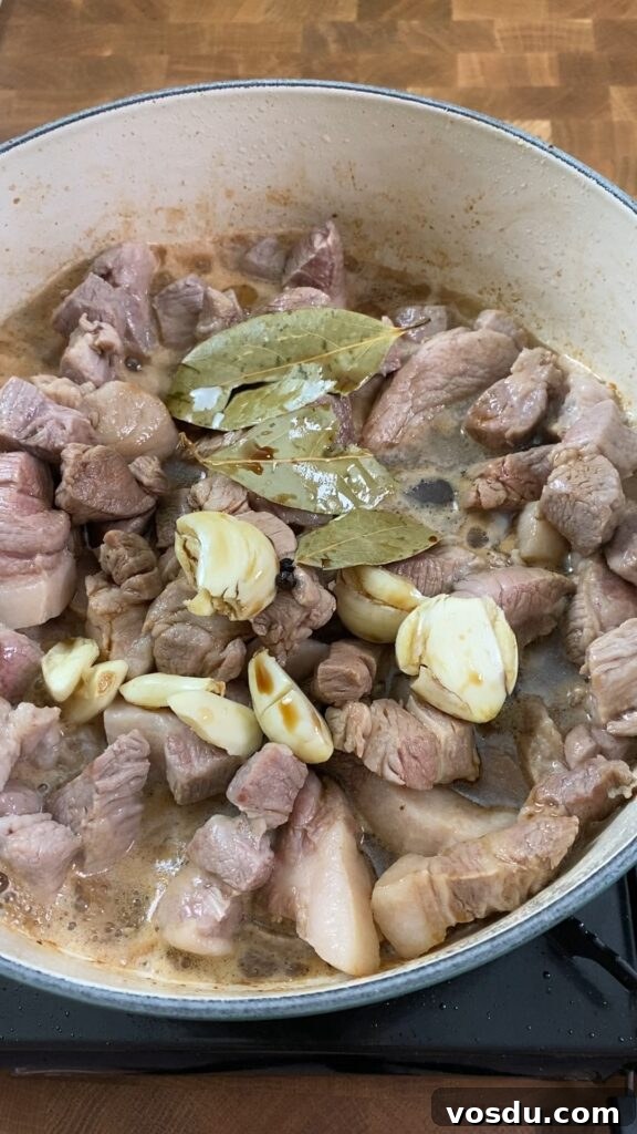 Authentic Filipino Pork Adobo Recipe — Tender, Savory Comfort 6 adding in bay leaves and garlic