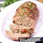 Smoky Grilled Meatloaf Recipe with Charred BBQ Glaze 2 Grilled meatloaf on a platter, 2 slices