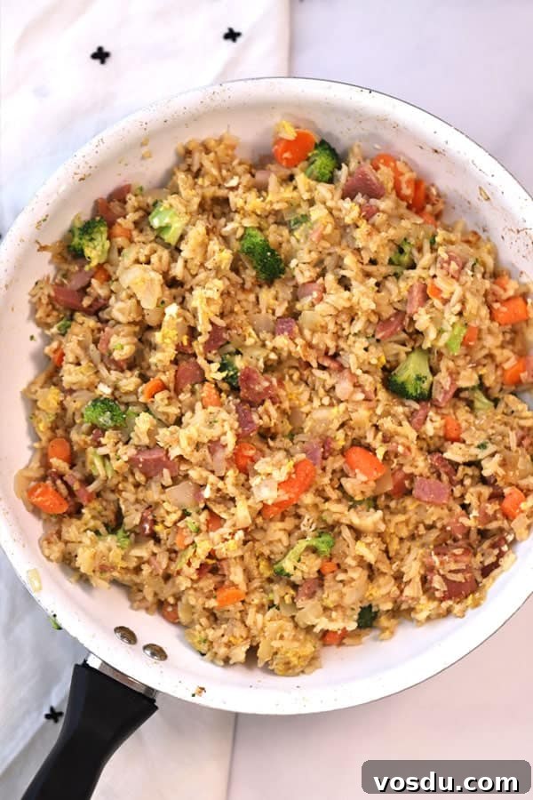 A skillet full of ham fried rice.