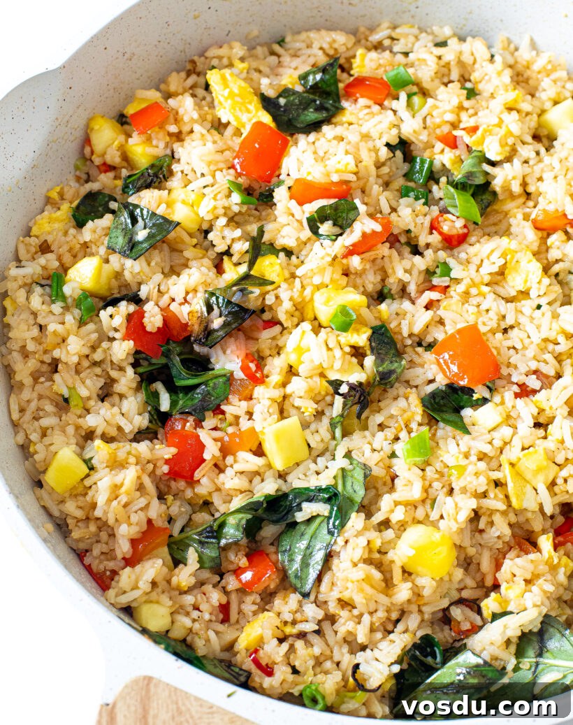 Authentic Thai Pineapple Fried Rice Recipe with Shrimp and Cashews 2 Pineapple Fried Rice in a white skillet.