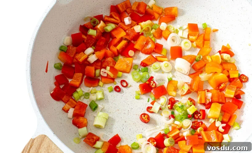 Authentic Thai Pineapple Fried Rice Recipe with Shrimp and Cashews 5 Veggies for fried rice in a white skillet.