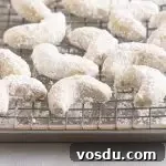 Buttery Almond Crescent Cookies Recipe for Tender, Nutty Crescents 7 cookies on a wire rack set on top of a baking sheet