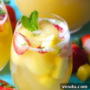 Sparkling Pineapple Punch Recipe with Video Tutorial 6 a tall glass of sparkling pineapple punch with fresh strawberries and mint