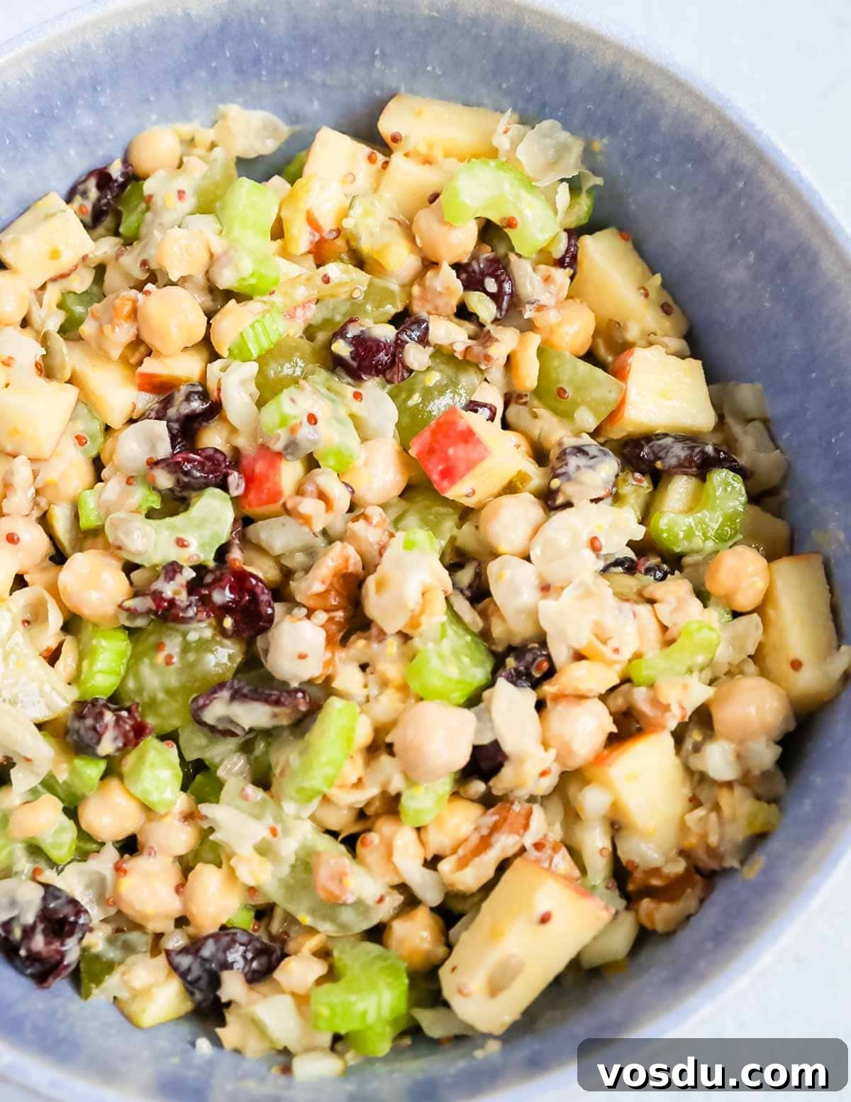 Flavorful Vegan Chickpea Salad with Lemon Herb Dressing 4 A close up of chickpea salad in a blue bowl.
