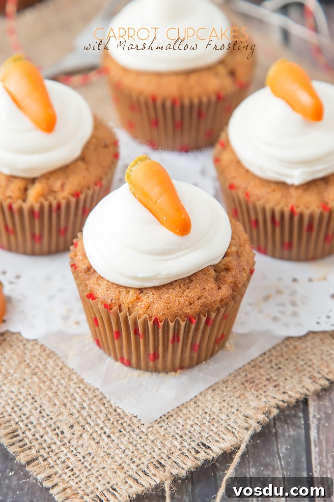 These Carrot Cupcakes are spicy, sweet, jam packed with shredded carrot and topped with a smooth, fluffy Marshmallow Frosting.