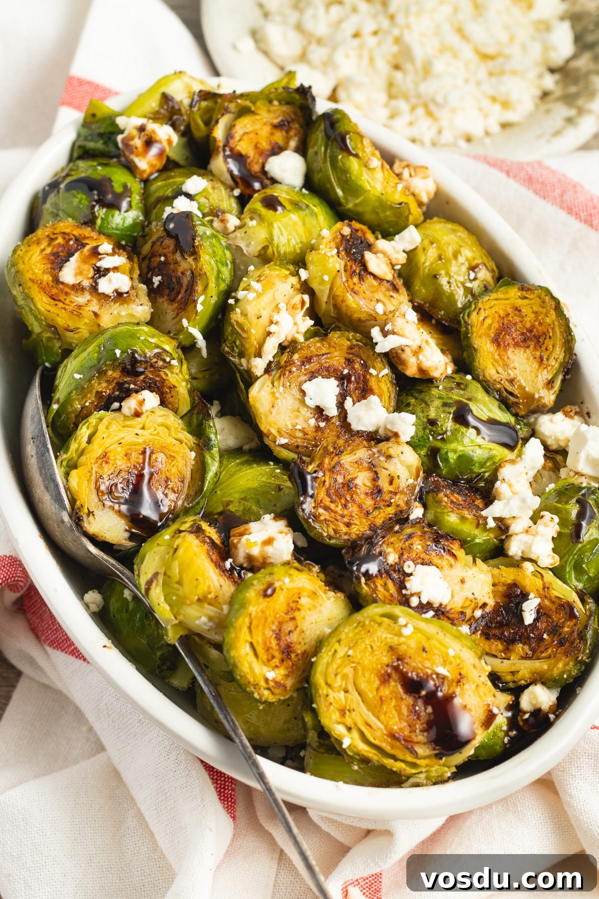 Crispy Roasted Brussels Sprouts with Feta and Lemon Zest 2 This is a picture of a bowl of Brussels sprouts with feta and balsamic glaze.