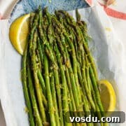 This is a square picture of a plate filled with lemon garlic asparagus.