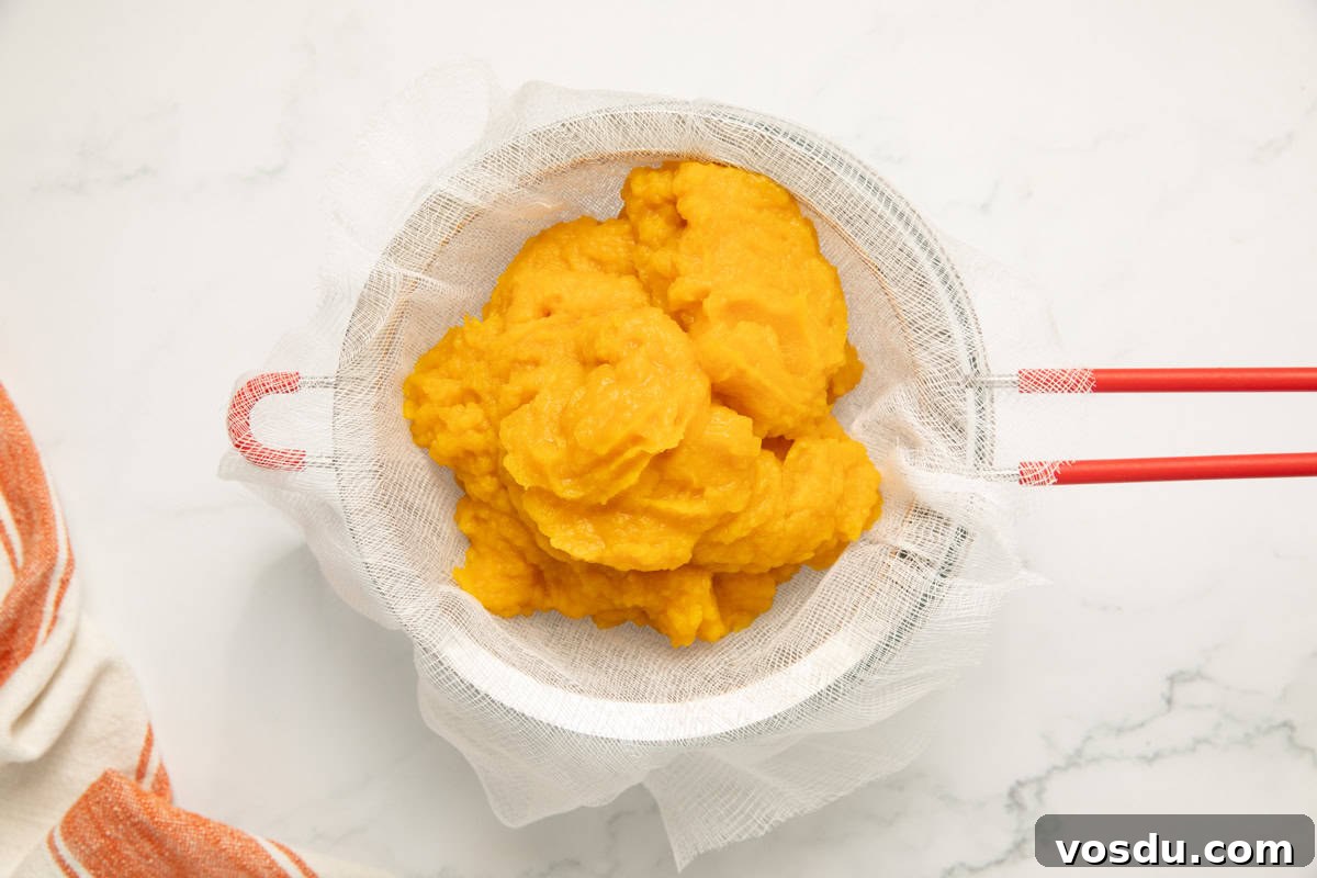 Homemade Pumpkin Puree From Scratch — Step-by-Step Recipe 8 fresh made pumpkin puree straining on a cheesecloth wrapped strainer