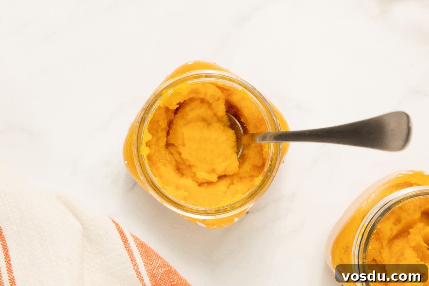 Homemade Pumpkin Puree From Scratch — Step-by-Step Recipe 9 a mason jar of pumpkin puree with a spoon in it