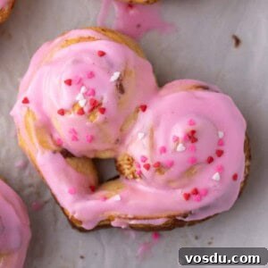 Heart-Shaped Cinnamon Rolls for Valentine’s Day Using Canned Dough 11 Frosted heart-shaped cinnamon rolls with pink icing and Valentine’s sprinkles