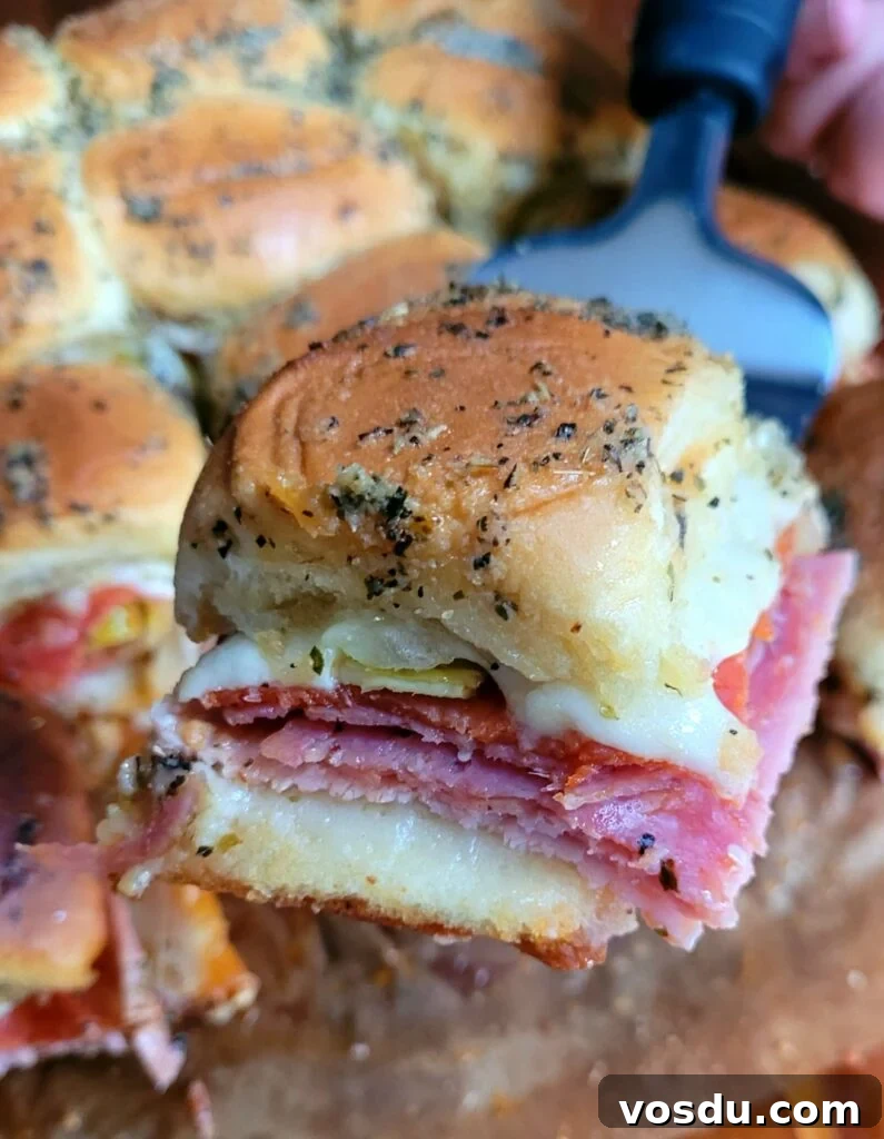 Italian Hawaiian Mini Roll Sliders Recipe 2 Mini Italian Hawaiian Roll Sliders fresh out of the oven, golden tops, melted provolone, and savory sweet sandwiches ready for a crowd-pleasing appetizer.