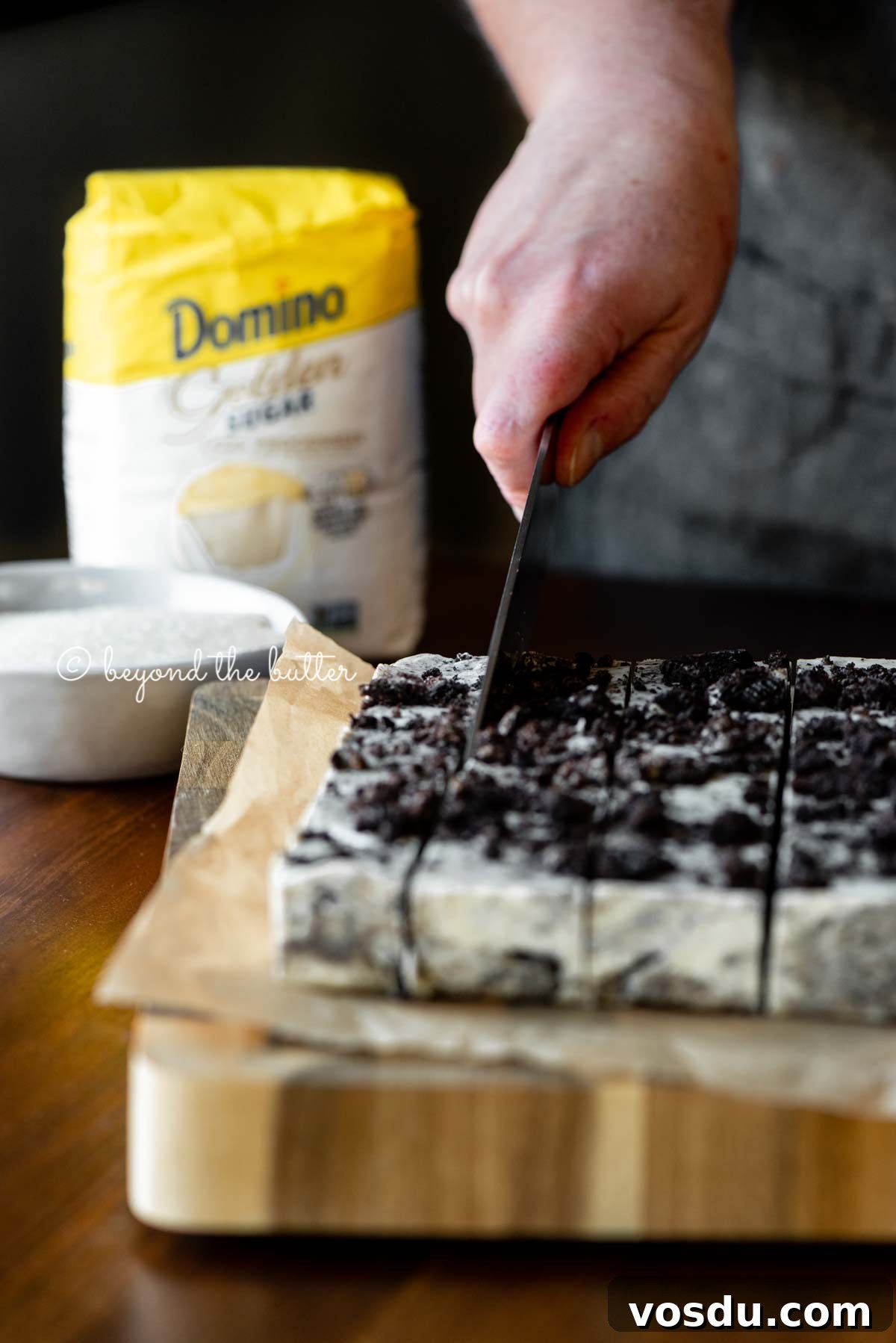 Cookies and Cream Fudge Recipe: Rich No-Bake Dessert Guide 4 Cutting the cookies and cream fudge with small bag of Domino® Golden Sugar in the background | All Images © Beyond the Butter®
