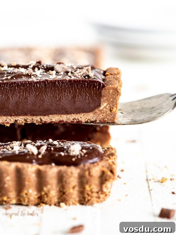 Cookies and Cream Fudge Recipe: Rich No-Bake Dessert Guide 10 Serving a slice of dark chocolate tart on white wood table.