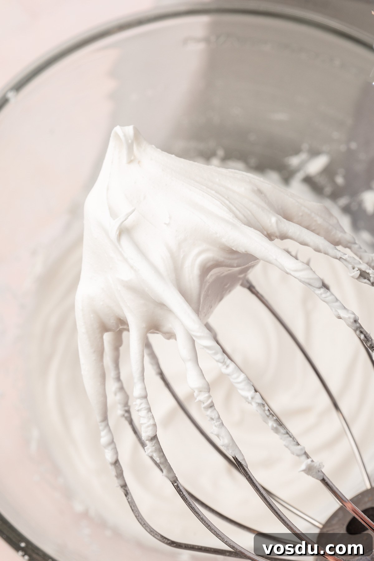 Perfect Royal Icing Recipe: Smooth, Glossy, and Pipe-Ready 7 A whisk covered in white royal icing with a medium stiff peak.
