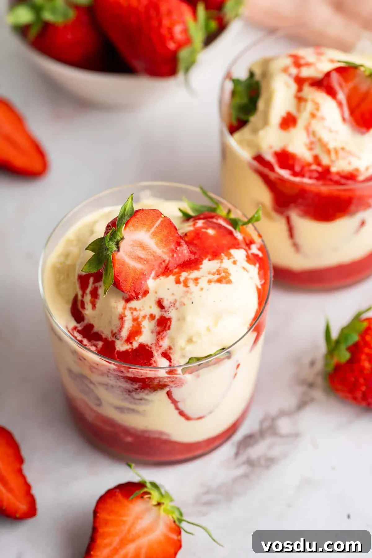 Decadent Homemade Strawberry Sundae Recipe 2 Two glass mugs full of a strawberry sundae.