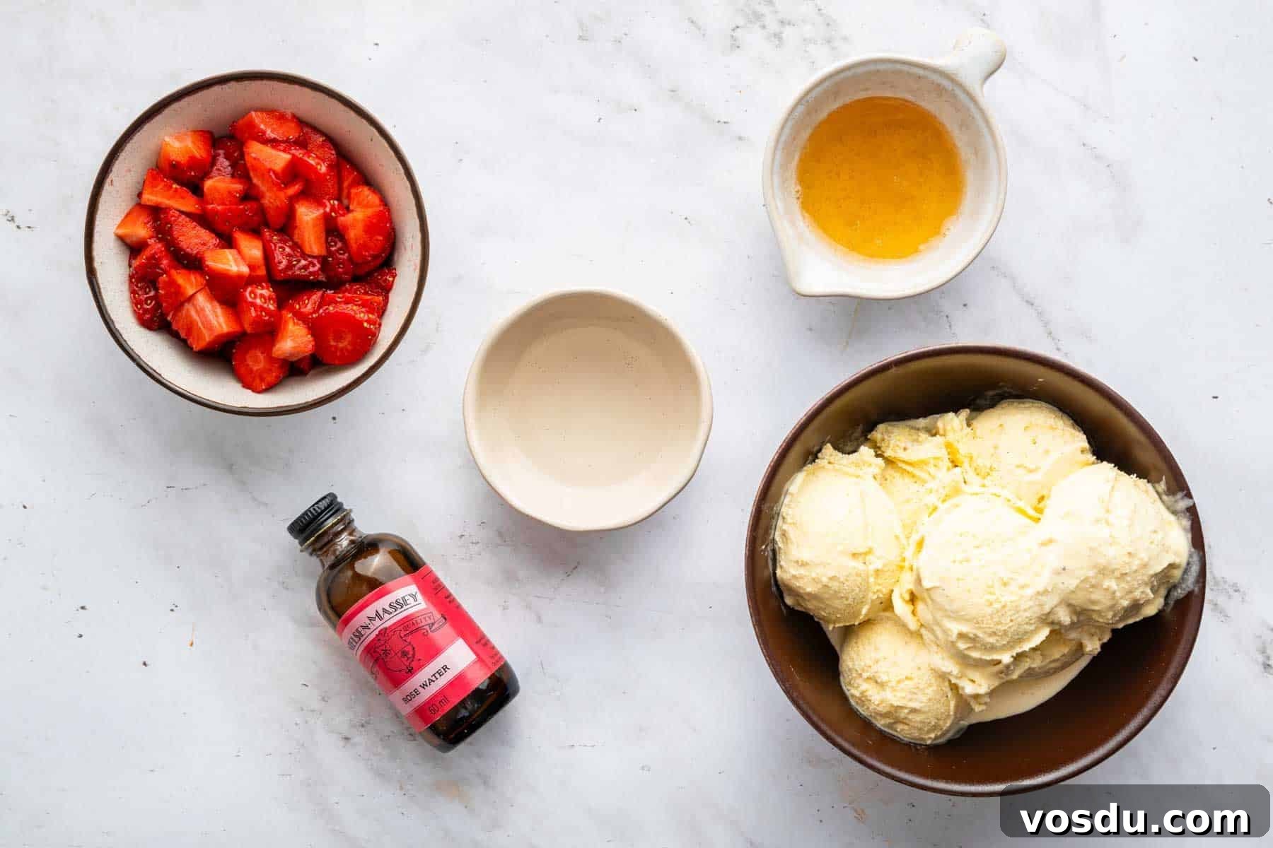 Decadent Homemade Strawberry Sundae Recipe 4 Bowl of chopped fruit, scoops of ice cream, and rose water bottle.