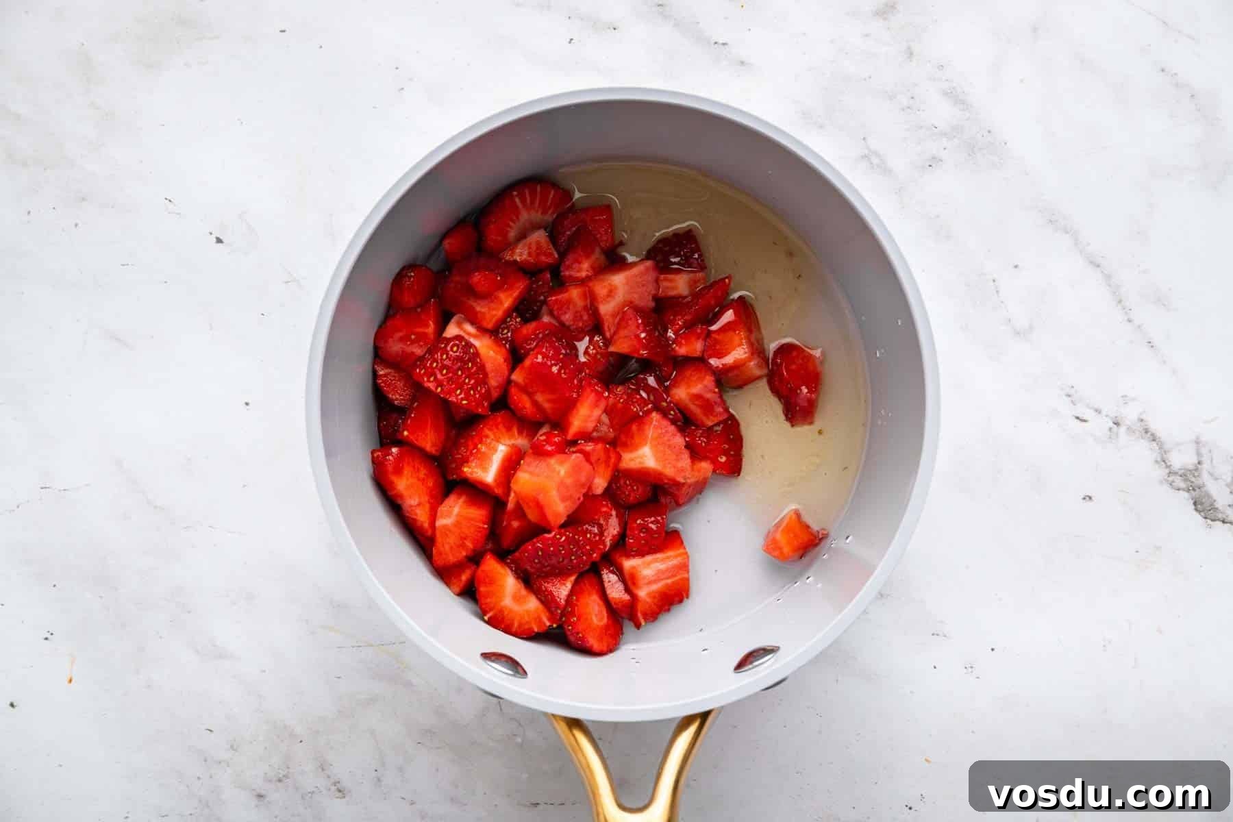 Decadent Homemade Strawberry Sundae Recipe 5 Fresh chopped red fruit in a small grey skillet.
