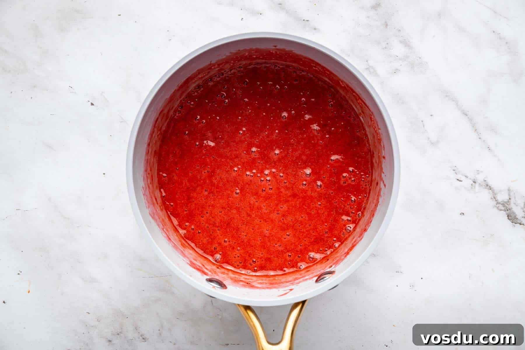 Decadent Homemade Strawberry Sundae Recipe 7 Bright red fruit sauce puree in grey skillet.