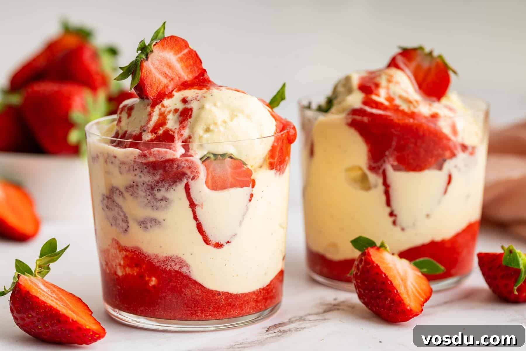 Decadent Homemade Strawberry Sundae Recipe 9 Horizontal image of two strawberry sundaes with fresh strawberries on top.