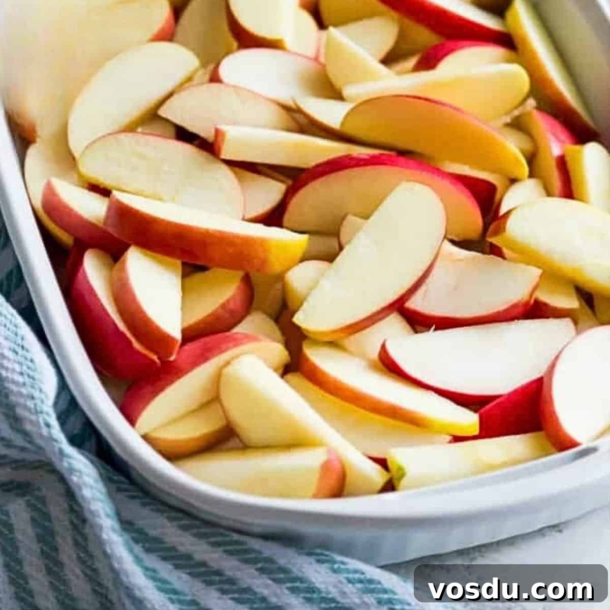 Baked Apple Slices with Homemade Caramel Sauce 4 A casserole dish filled with chopped red apples.