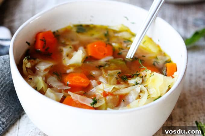 Slow Cooker Cabbage Soup - easy, vegan, gluten-free. Set it and forget it. Let your crockpot cook your dinner. Slow cooker cabbage soup in a white bowl with spoon