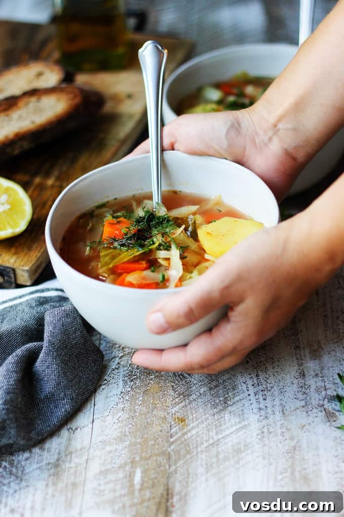 Slow Cooker Cabbage Soup - easy, vegan, gluten-free. Set it and forget it. Let your crockpot cook your dinner. Serving slow cooker cabbage soup in a bowl