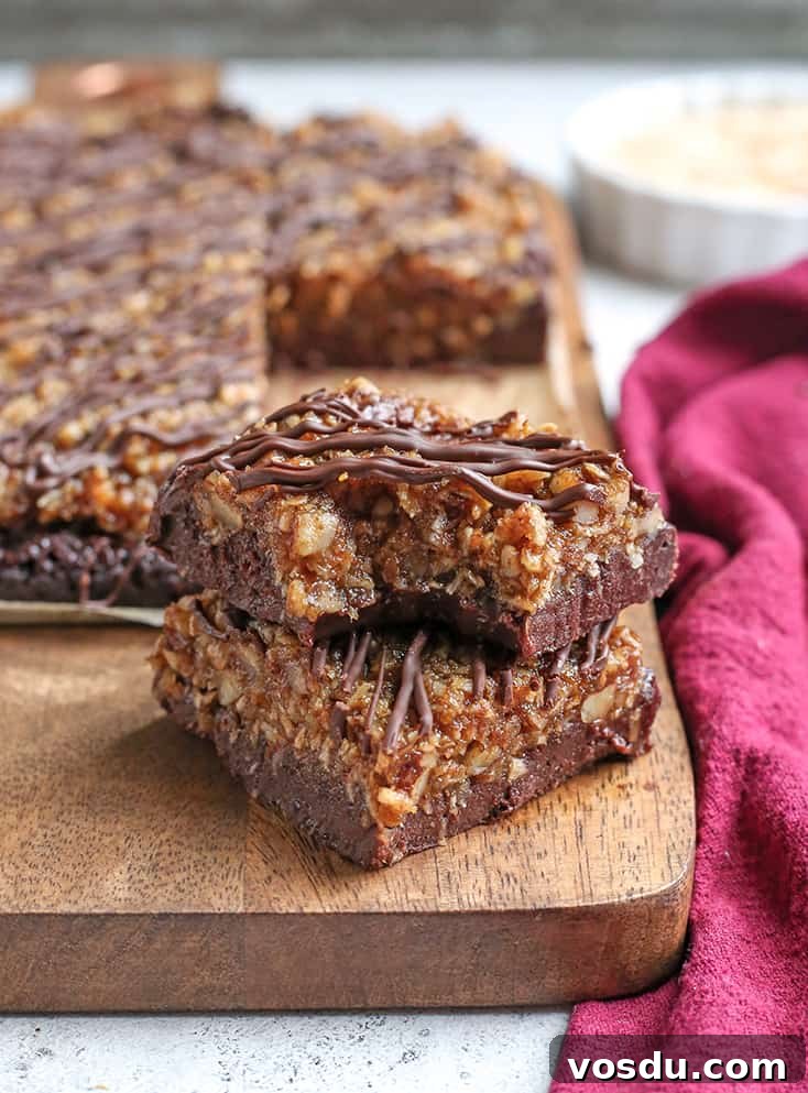 Paleo Vegan German-Style Chocolate Brownies 4 bite taken out of german chocolate brownie stacked on another one