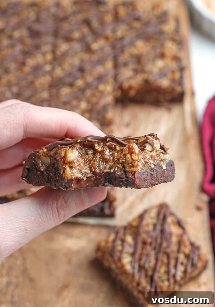 Paleo Vegan German-Style Chocolate Brownies 8 hand holding a german chocolate brownie with a bite taken out