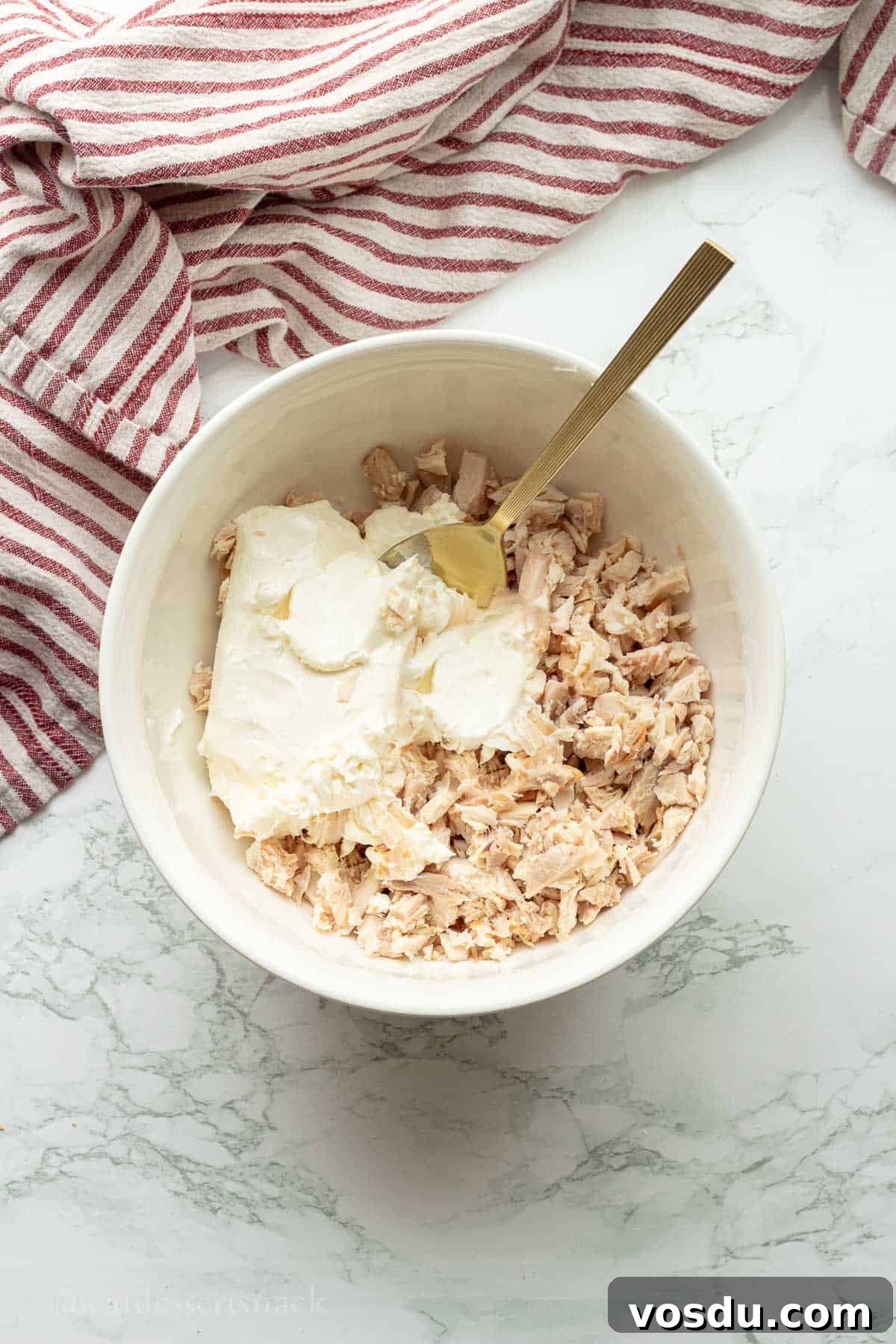 Cranberry Chicken Salad with Toasted Pecans and Citrus Vinaigrette 5 Cream cheese, sour cream, and cooked chicken in white bowl with gold spoon.