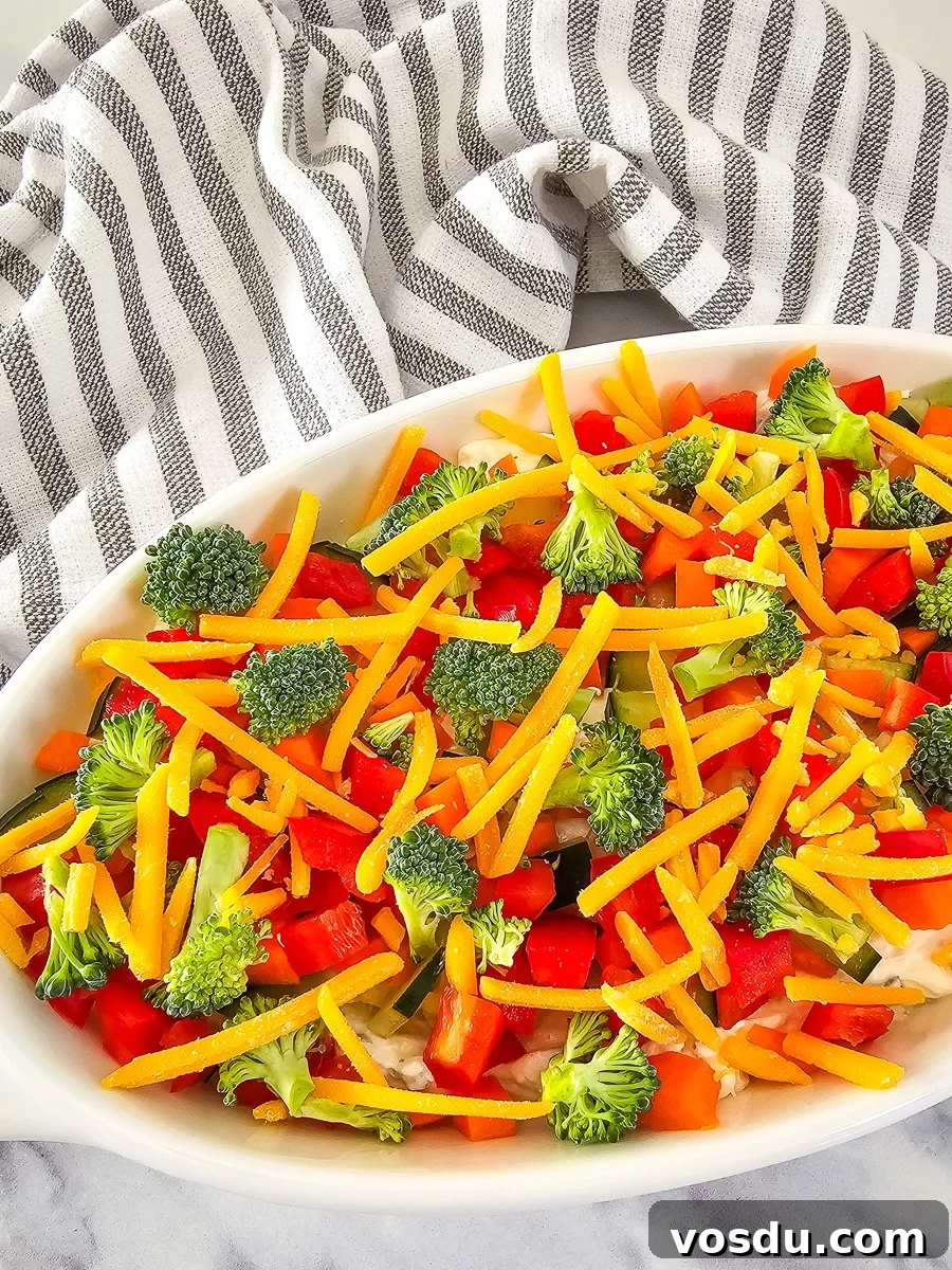 Veggie pizza dip in a white bowl.