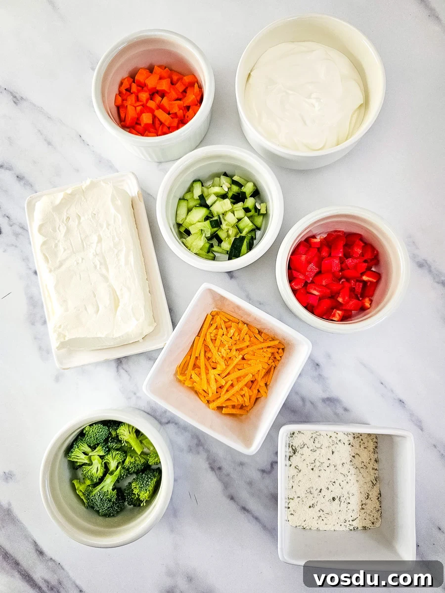 Ingredients for veggie pizza dip in small bowls on counter.