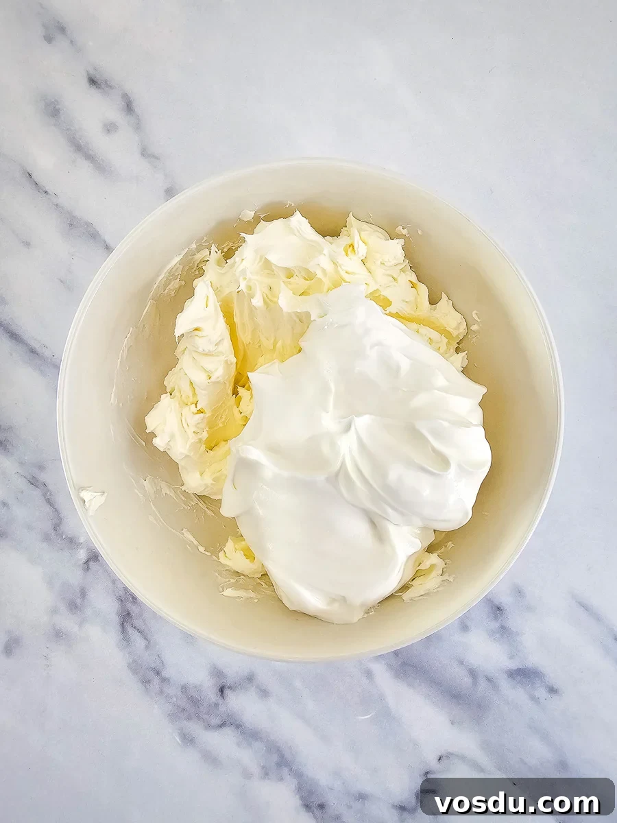 Cream cheese and sour cream with ranch seasoning in white bowl.