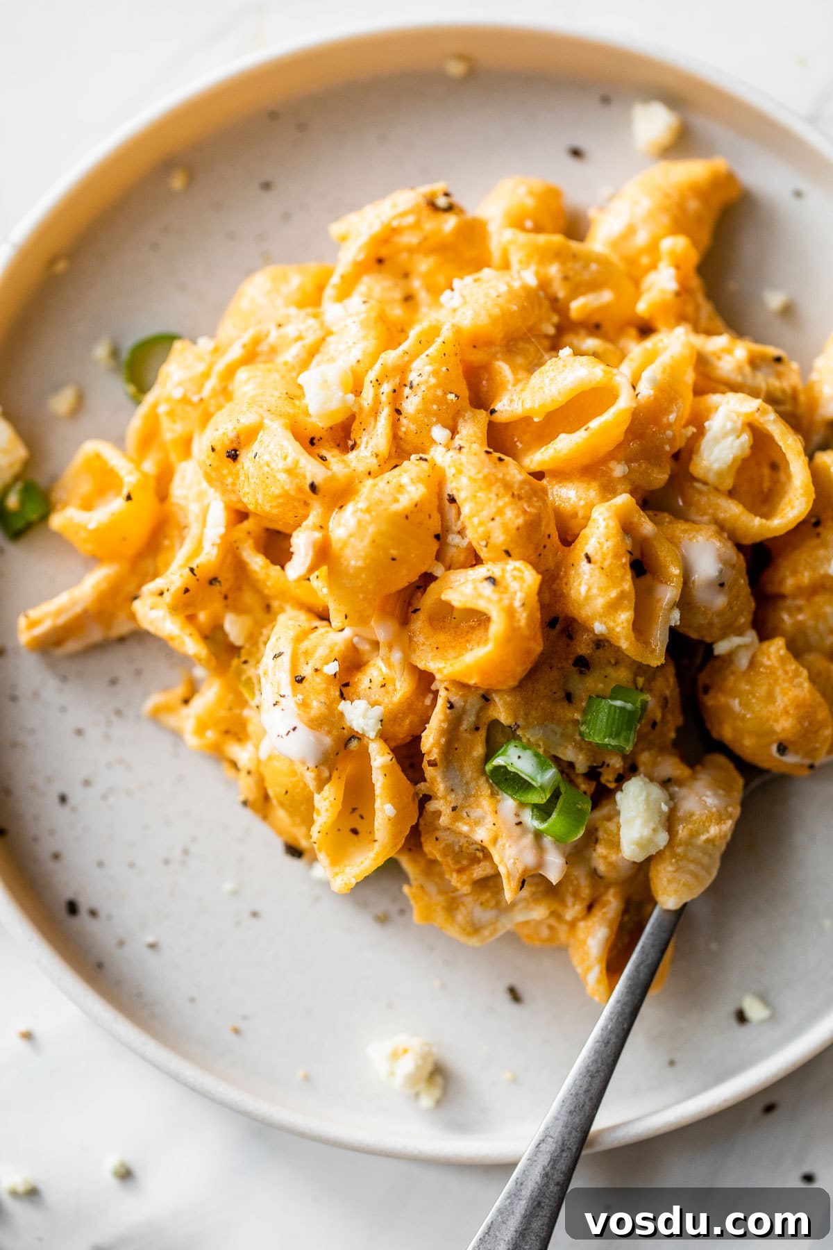 Creamy Buffalo Chicken Pasta Recipe with Tangy Wing Sauce 6 buffalo chicken pasta on a plate topped with green onions