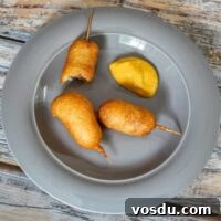 Crispy Mini Corn Dogs Recipe: Bite-Sized Party Snack 2 mini corn dogs on a plate with mustard