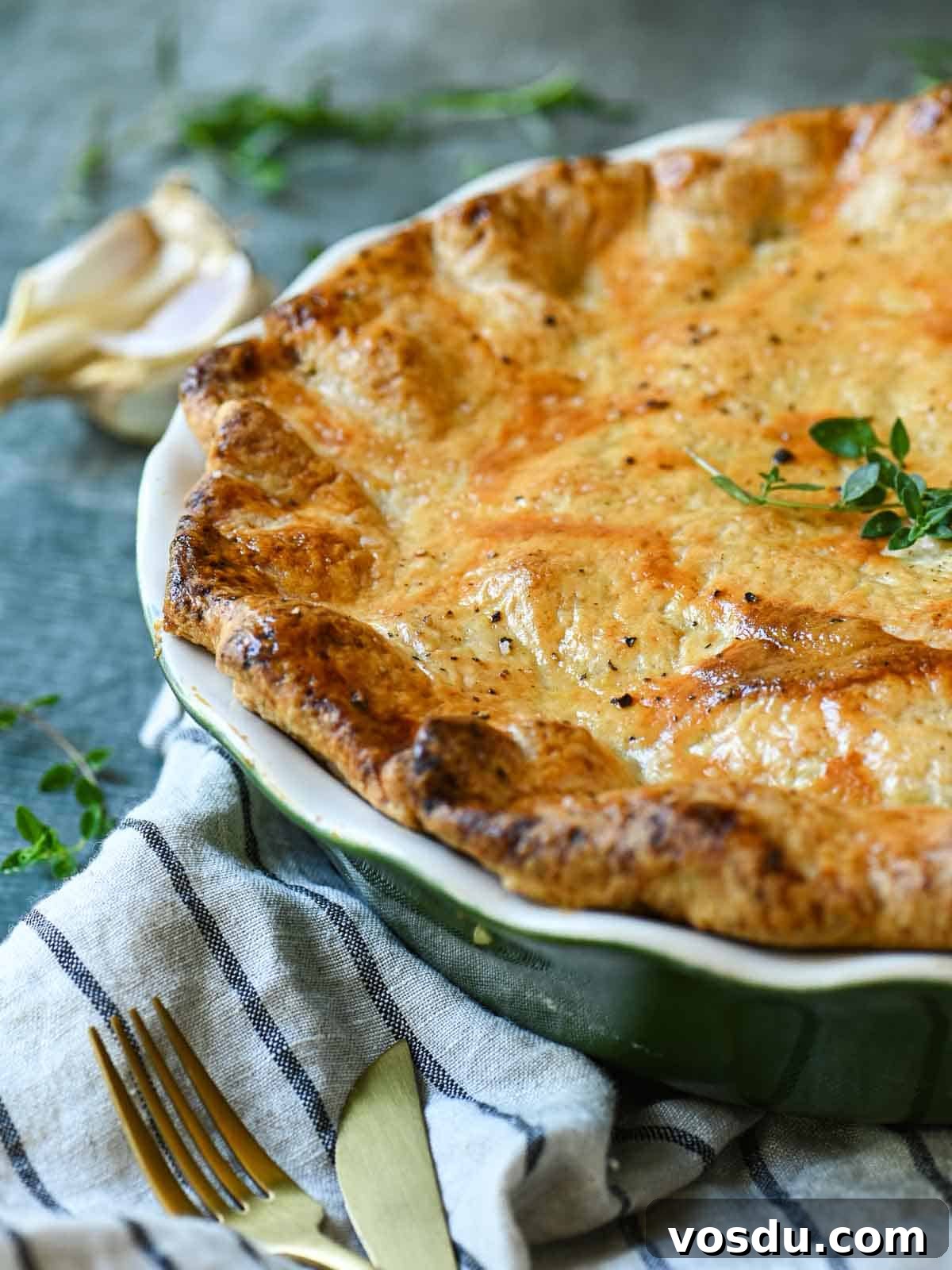Close-up of chicken pie showing the crust with herbs next to it.