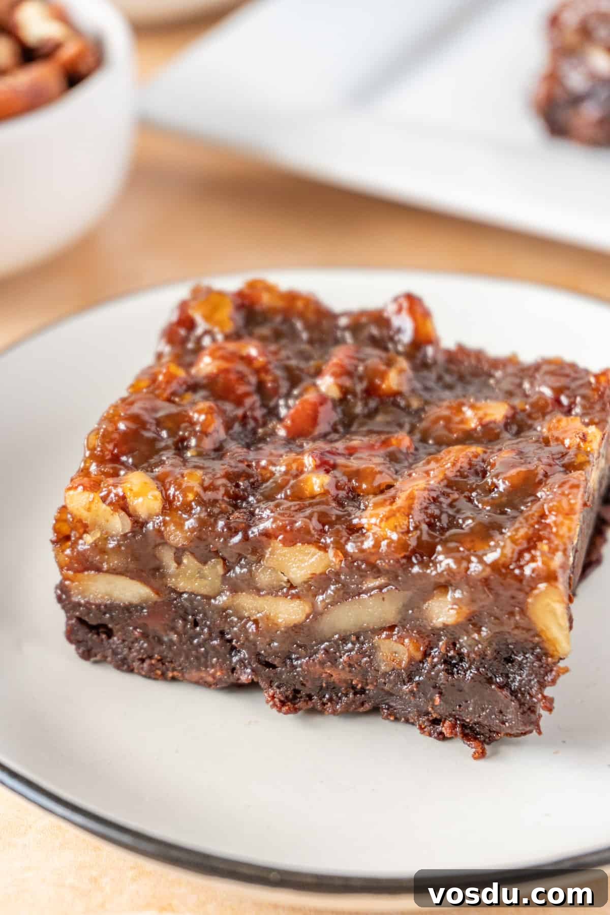 A square piece of Pecan Pie Brownie on white plate.