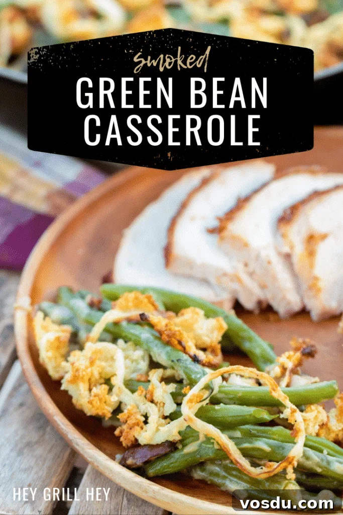 Green bean casserole on a plate next to sliced meat. Text overlay reads, 'Smoked Green Bean Casserole.'
