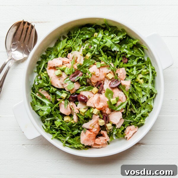 Salmon, Arugula, and Avocado Salad with Lemon Vinaigrette in serving dish.