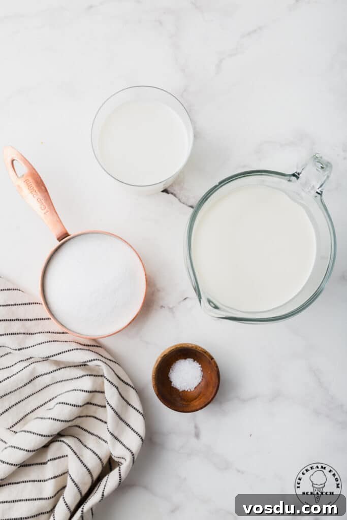 Ingredients needed for sweet cream ice cream, in separate bowls on a marble counter.